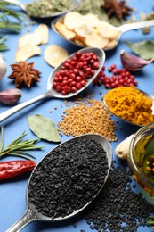 Photo of Different aromatic spices on blue background, closeup