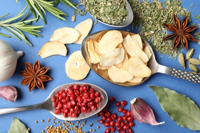 Photo of Different aromatic spices on blue background, flat lay