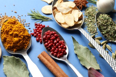 Photo of Different aromatic spices on blue background, closeup