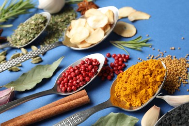 Photo of Different aromatic spices on blue background, closeup