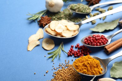 Photo of Different aromatic spices on blue background, closeup
