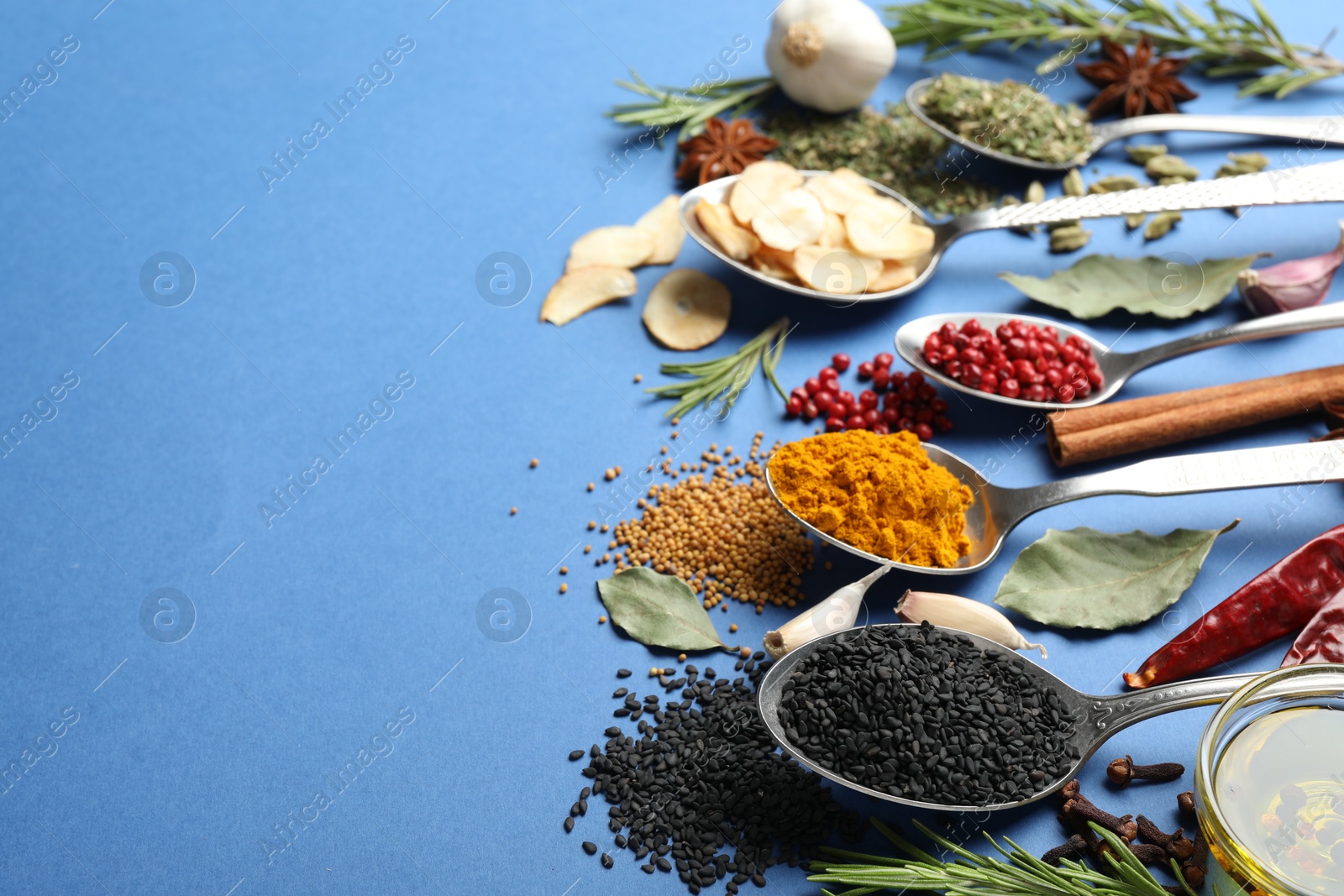 Different aromatic spices on blue background, closeup. Space for text Photo of Different aromatic spices on blue background, closeup. Space for text