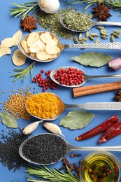 Photo of Different aromatic spices and oil on blue background, flat lay
