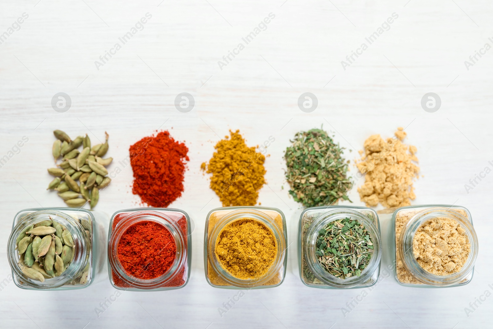 Different aromatic spices in jars on white table, flat lay. Space for text Photo of Different aromatic spices in jars on white table, flat lay. Space for text
