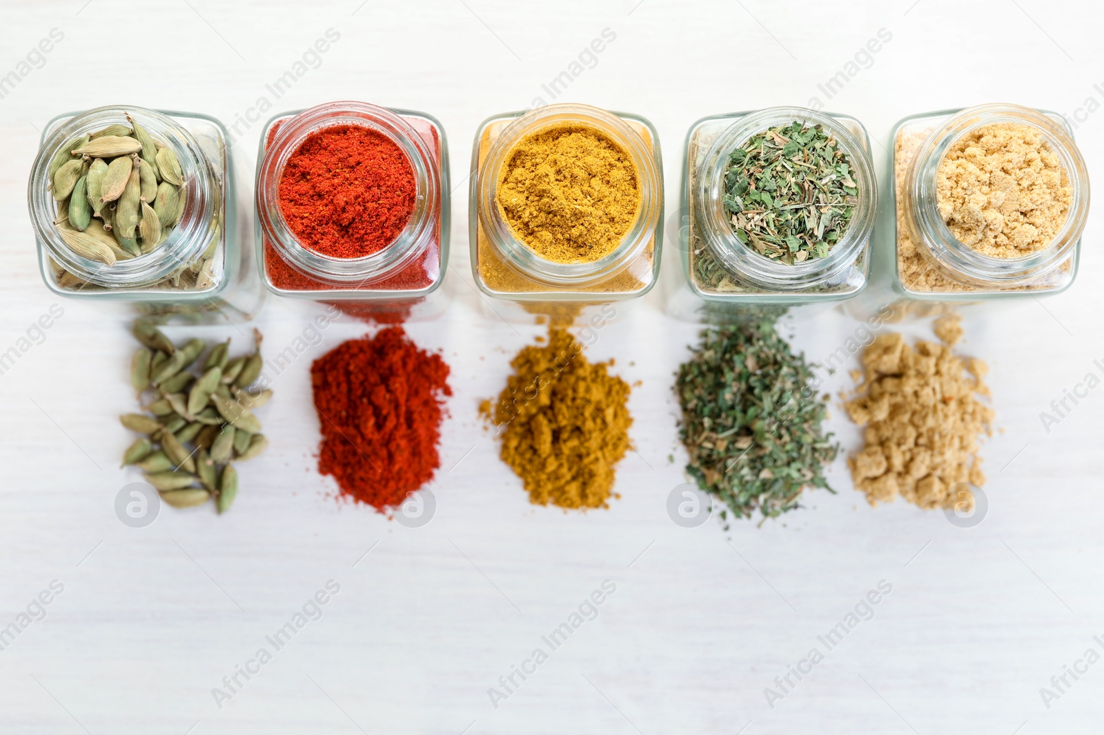 Different aromatic spices in jars on white table, flat lay Photo of Different aromatic spices in jars on white table, flat lay