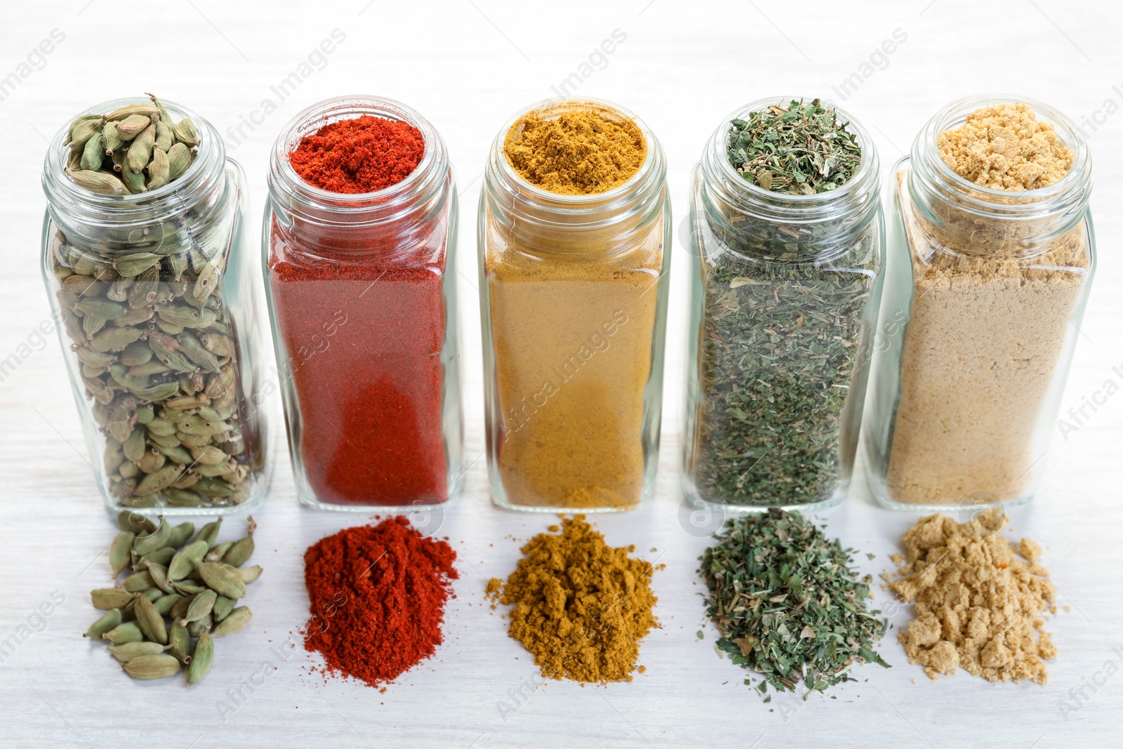 Different aromatic spices in jars on white table, closeup Photo of Different aromatic spices in jars on white table, closeup
