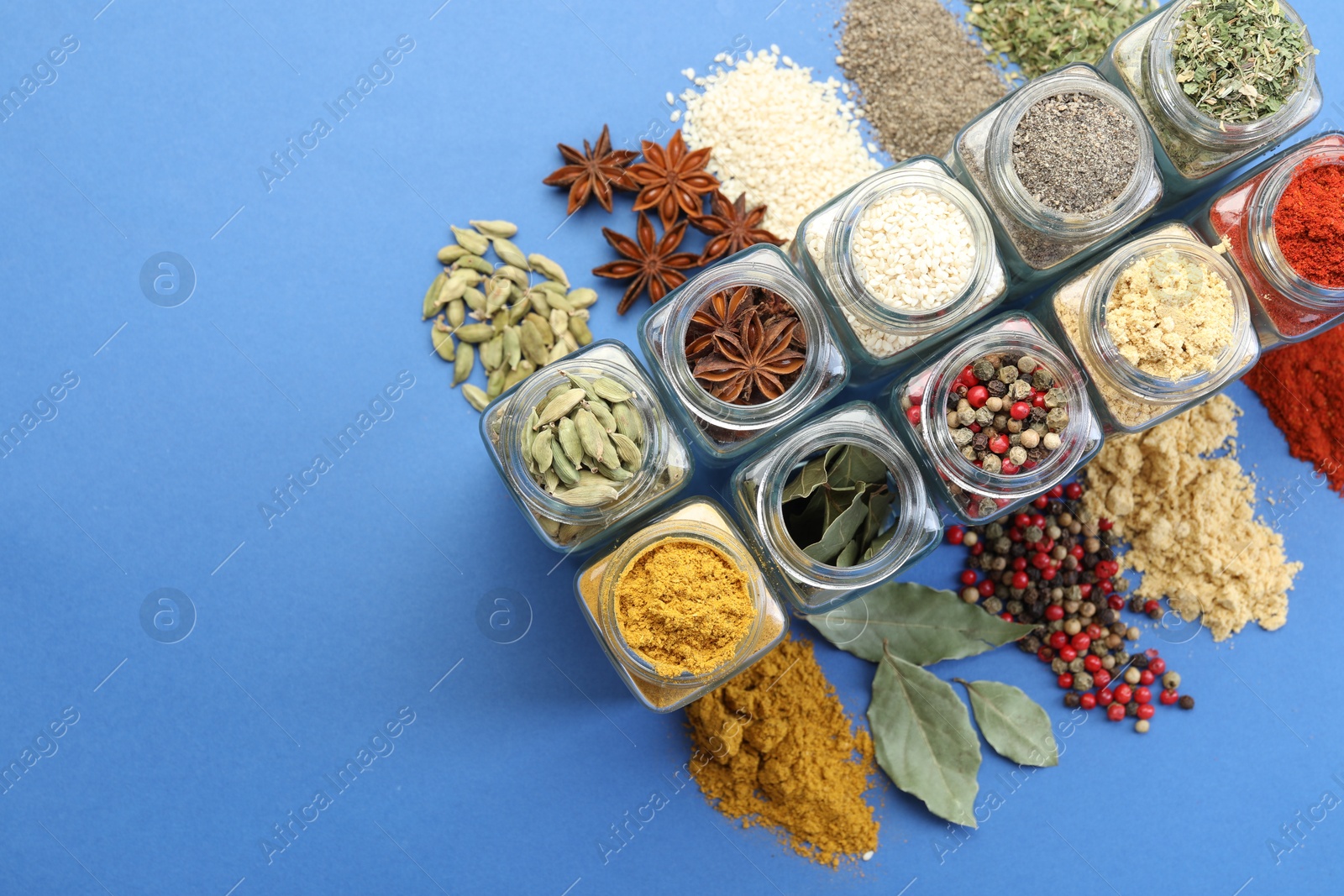 Different aromatic spices in jars on blue background, flat lay. Space for text Photo of Different aromatic spices in jars on blue background, flat lay. Space for text