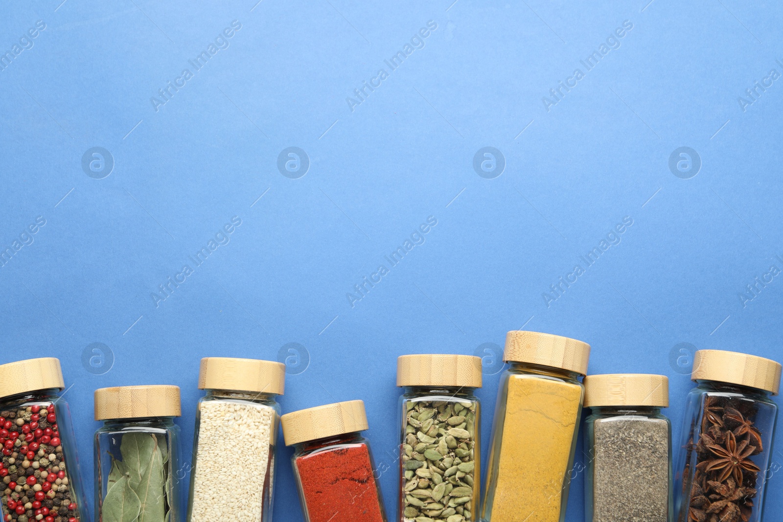 Different aromatic spices in jars on blue background, flat lay. Space for text Photo of Different aromatic spices in jars on blue background, flat lay. Space for text