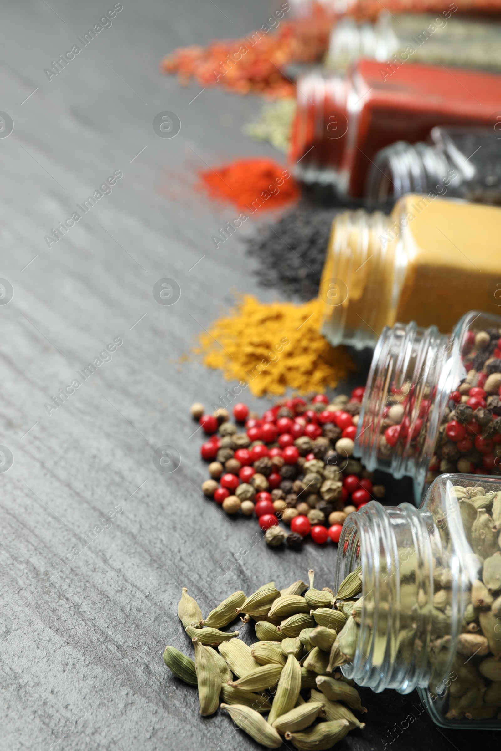 Different aromatic spices in jars on black table, closeup Photo of Different aromatic spices in jars on black table, closeup