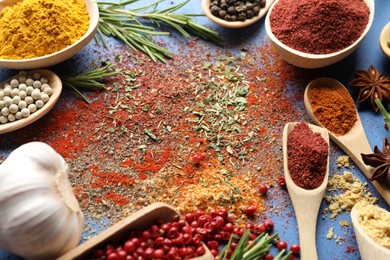 Photo of Different aromatic spices on blue background, closeup