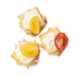 Photo of Tasty crackers with cream cheese and tomatoes isolated on white, top view