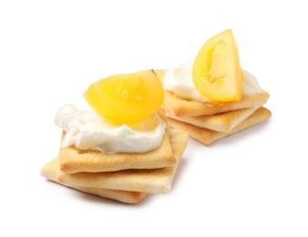 Photo of Tasty crackers with cream cheese and tomatoes isolated on white