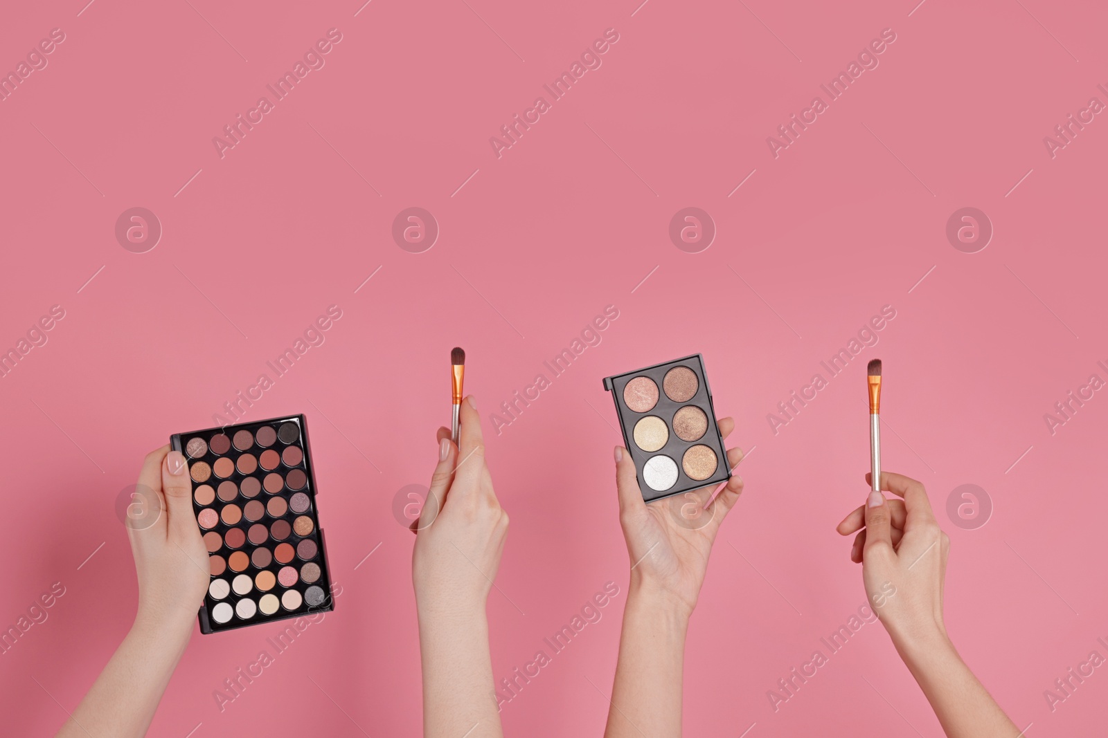 Women with eyeshadow palettes and brushes on pink background, closeup. Space for text Photo of Women with eyeshadow palettes and brushes on pink background, closeup. Space for text