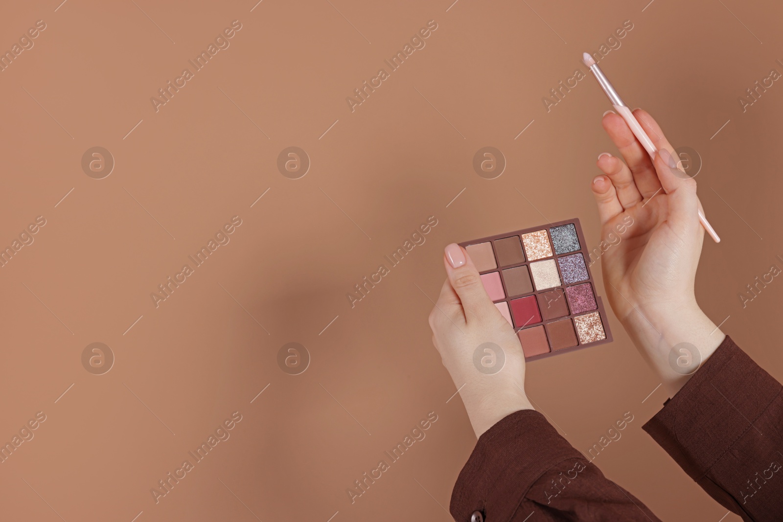 Woman with eyeshadow palette and brush on beige background, closeup. Space for text Photo of Woman with eyeshadow palette and brush on beige background, closeup. Space for text