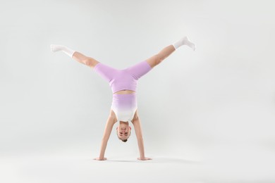 Photo of Girl in stylish clothes dancing on light grey background