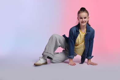 Photo of Girl in stylish clothes dancing on color background