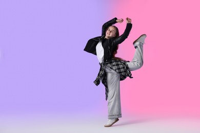 Photo of Girl in stylish clothes dancing on color background