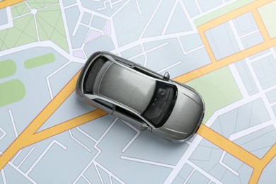 Photo of Road trip concept. Car model on city map, top view