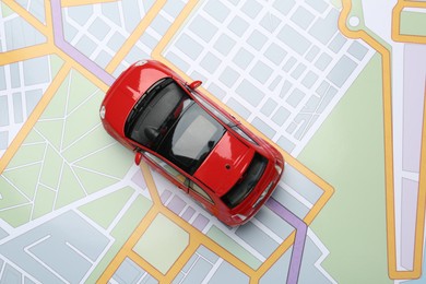 Photo of Road trip concept. Car model on city map, top view