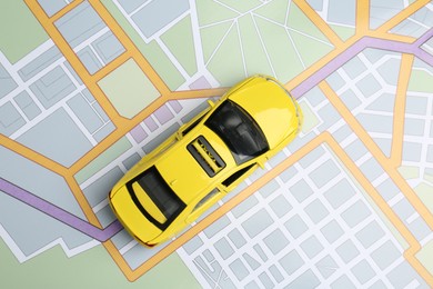 Photo of Road trip concept. Car model on city map, top view