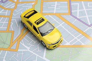 Photo of Road trip concept. Car model on city map, above view
