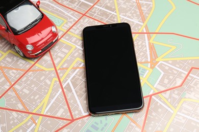Photo of Road trip concept. Smartphone and car model on city map