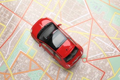 Photo of Road trip concept. Car model on city map, top view