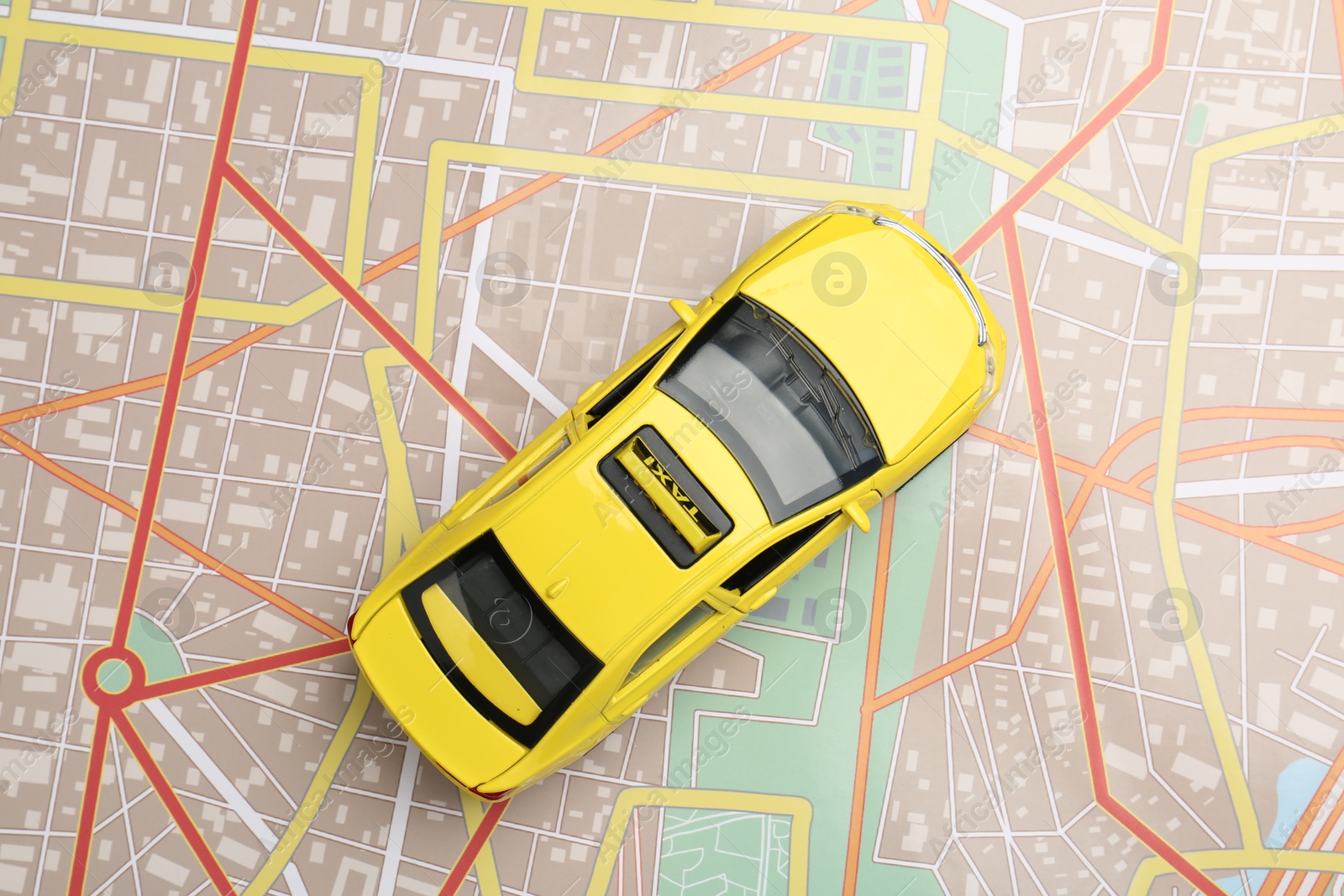 Road trip concept. Car model on city map, top view Photo of Road trip concept. Car model on city map, top view