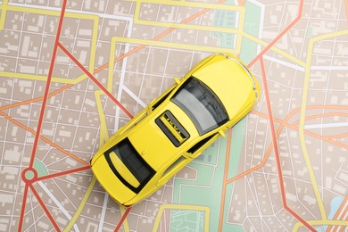 Photo of Road trip concept. Car model on city map, top view