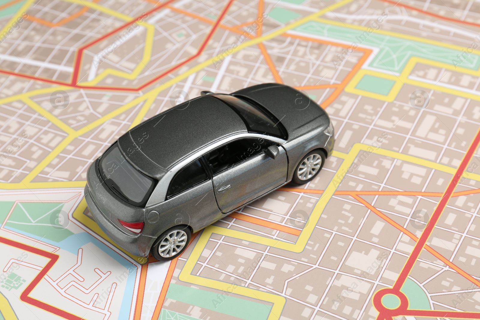 Photo of Road trip concept. Car model on city map, closeup
