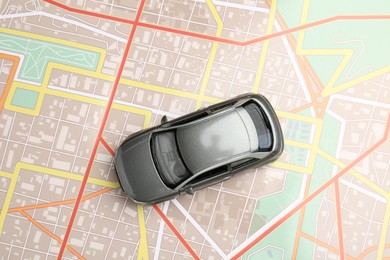 Photo of Road trip concept. Car model on city map, top view
