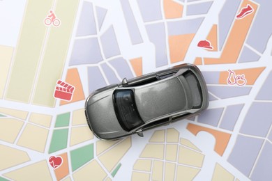 Photo of Road trip concept. Car model on city map, top view