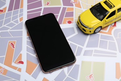 Photo of Road trip concept. Smartphone and car model on city map