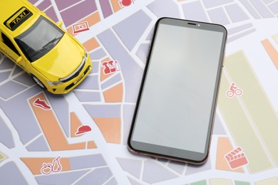 Photo of Road trip concept. Smartphone and car model on city map, above view
