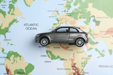 Photo of Road trip concept. Car model on world map, top view