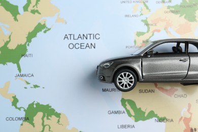 Photo of Road trip concept. Car model on world map, top view