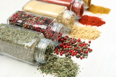 Photo of Different aromatic spices in jars on white table, closeup