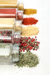 Photo of Different aromatic spices in jars on white table, closeup