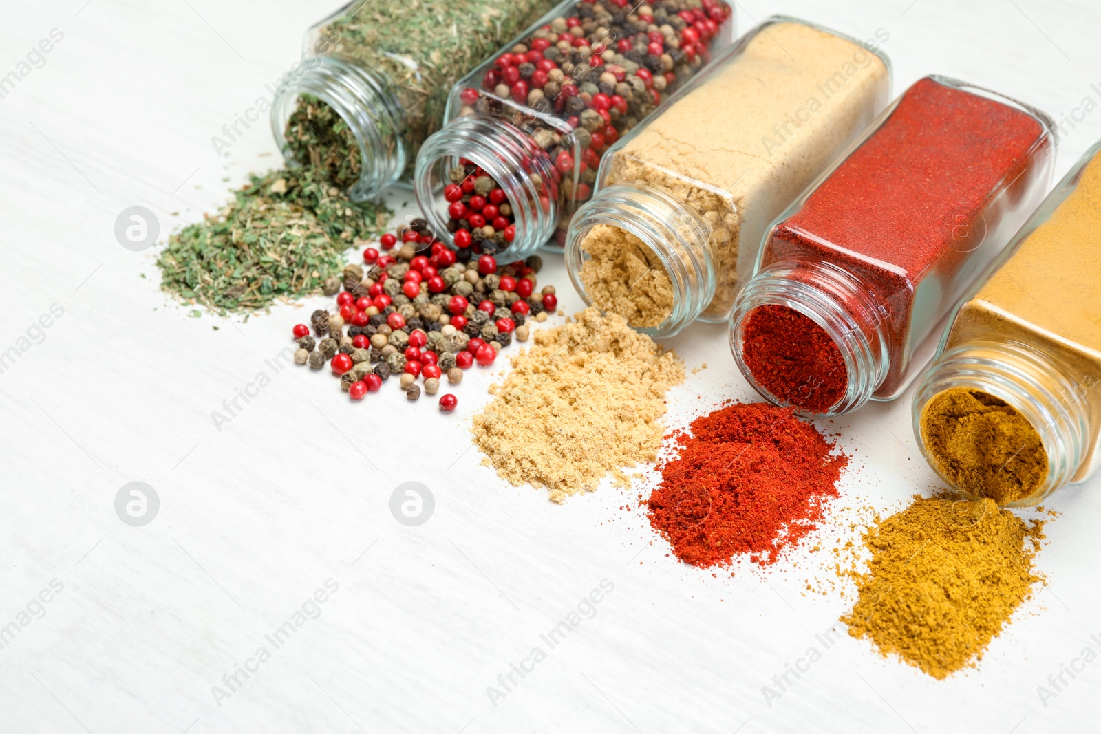 Different aromatic spices in jars on white table Photo of Different aromatic spices in jars on white table