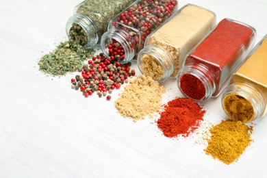 Photo of Different aromatic spices in jars on white table