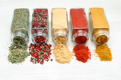 Photo of Different aromatic spices in jars on white table