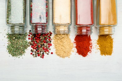 Photo of Different aromatic spices in jars on white table, flat lay
