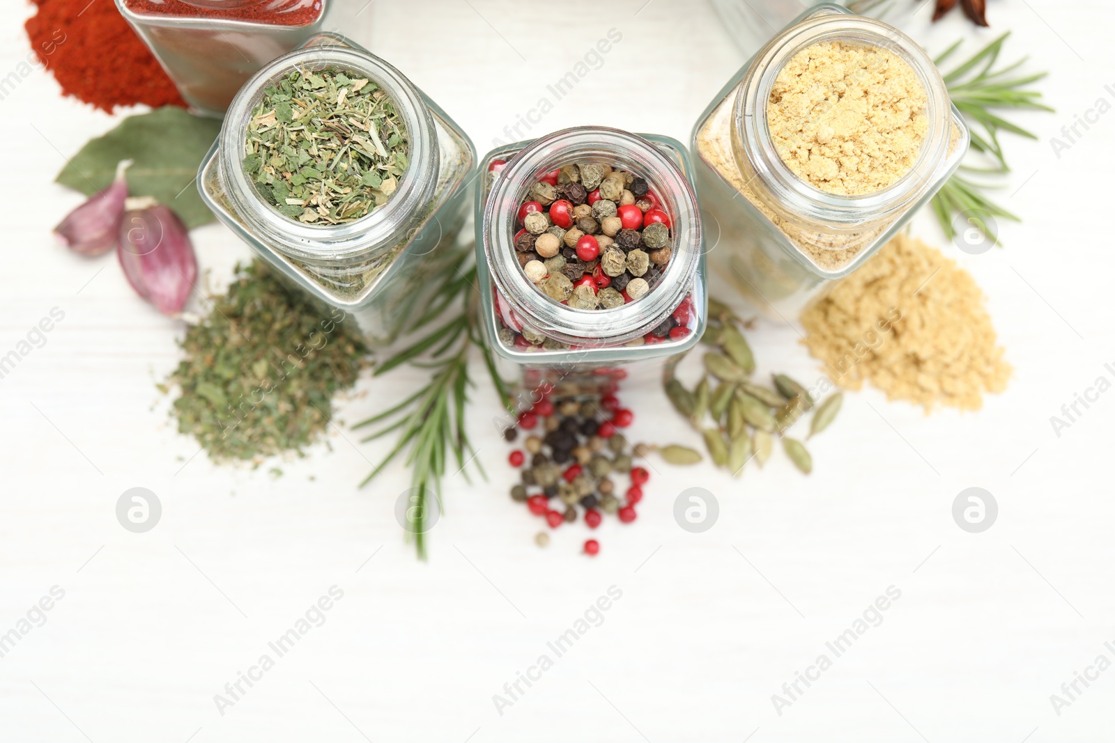 Different aromatic spices in jars on white table, flat lay Photo of Different aromatic spices in jars on white table, flat lay