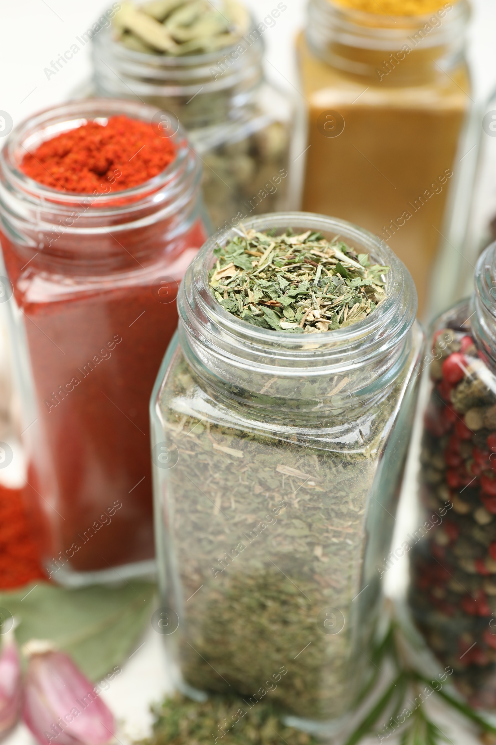 Different aromatic spices in jars on white table, closeup Photo of Different aromatic spices in jars on white table, closeup