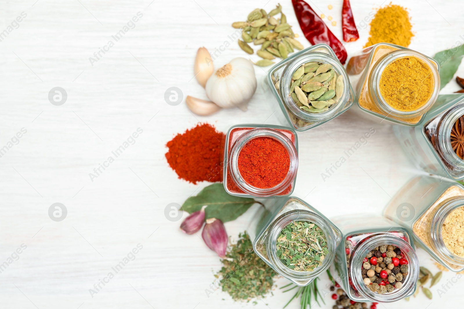 Different aromatic spices in jars on white table, flat lay. Space for text Photo of Different aromatic spices in jars on white table, flat lay. Space for text