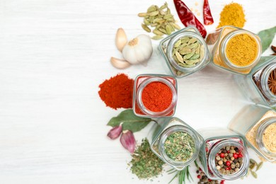 Photo of Different aromatic spices in jars on white table, flat lay. Space for text