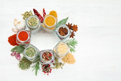 Photo of Different aromatic spices in jars on white table, flat lay. Space for text