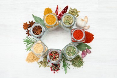 Photo of Different aromatic spices in jars on white table, flat lay