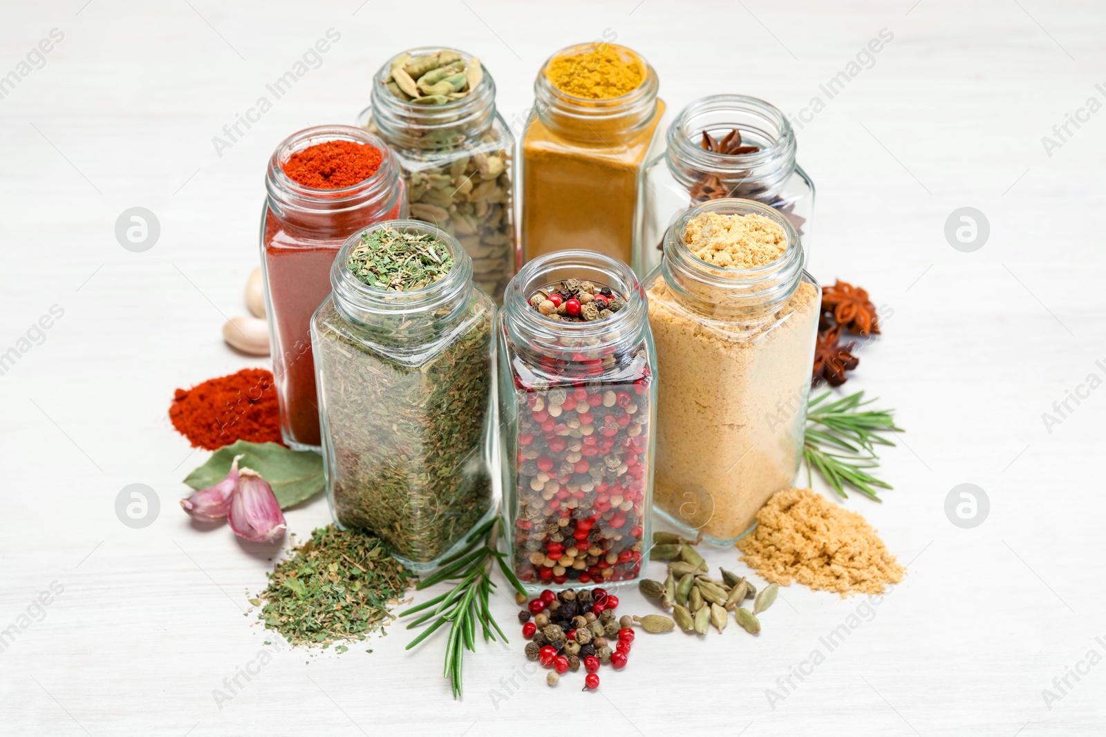 Different aromatic spices in jars on white table, closeup Photo of Different aromatic spices in jars on white table, closeup