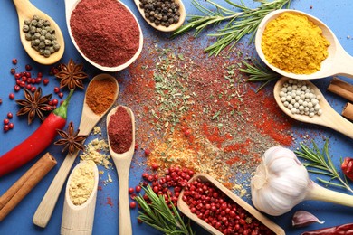 Photo of Different aromatic spices on blue background, flat lay